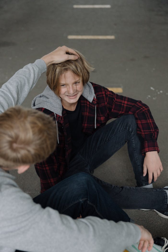 services-hero Two young boys enjoy a playful and bonding moment outdoors, sitting together and smiling.